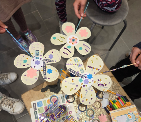 Enfants montrant leurs fleurs des adultes de confiance réalisées lors d’un atelier de prévention du harcèlement scolaire